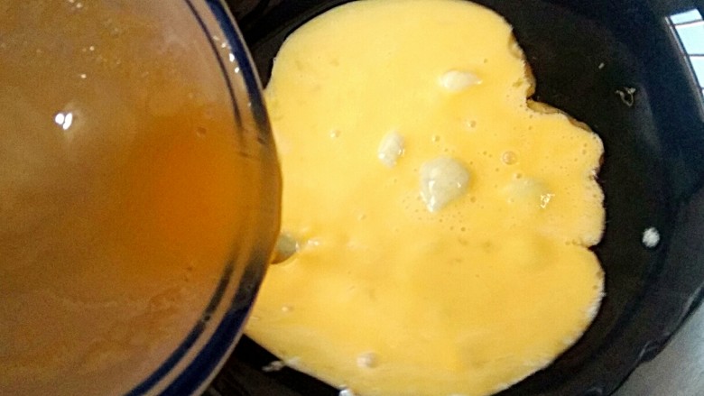 香椿芽炒蛋,锅中适量油烧至七成热时，倒入打好的鸡蛋液。