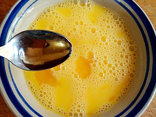 香椿芽炒蛋,鸡蛋在碗中打散，加入15ml料酒，搅打均匀。