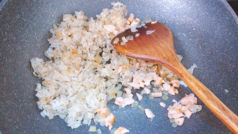 黑椒牛油果三文鱼炒饭,倒入洋葱和三文鱼，翻炒均匀