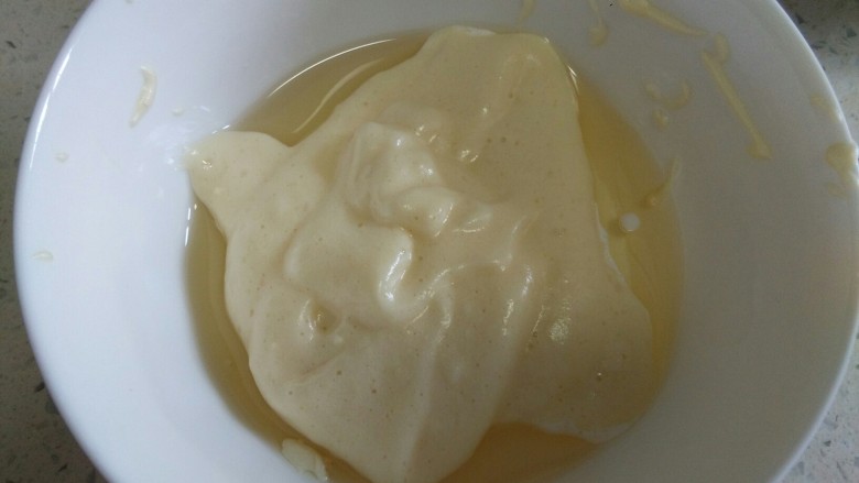 分蛋打发海绵蛋糕,这时候挖一刮刀面糊到黄油牛奶混合物里