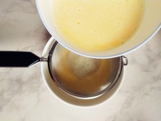 #宝宝辅食#奶酪馒头蒸蛋,取另一个容器，倒入三分之一的蛋液，用筛子过滤下