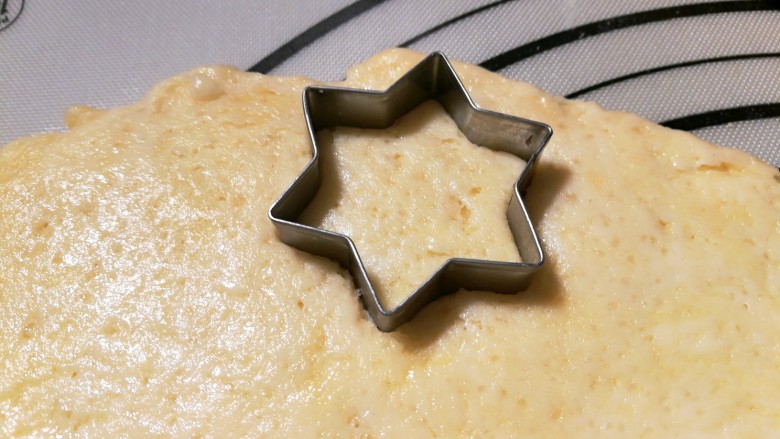 奶酪司康,取一个自己喜欢的饼干模具，在面饼上压下去。如果没有饼干模具，就用刀切成小方块也可以，这一步随自己喜好。