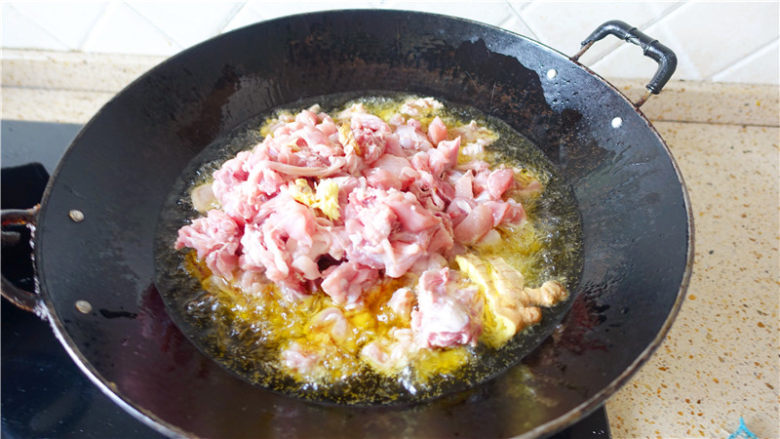 冷吃兔,炒锅上火烧热，倒油烧至五成热，将腌好的兔肉及生姜块倒入。
