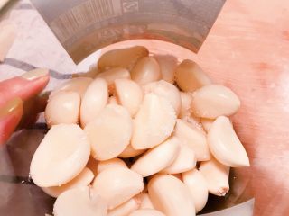 舌尖上的翡翠碧玉——陈醋腊八蒜,将蘸满白糖的蒜瓣儿放入罐头瓶内。
