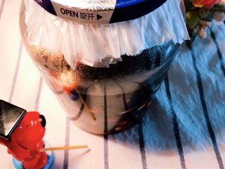 舌尖上的翡翠碧玉——陈醋腊八蒜,醋酸会腐蚀金属瓶盖，因此垫上保鲜膜封住罐头瓶口后，再拧紧罐头瓶盖。