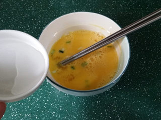XO酱虾仁蛋炒饭,将鸡蛋打散加葱花和少许清水搅拌均匀