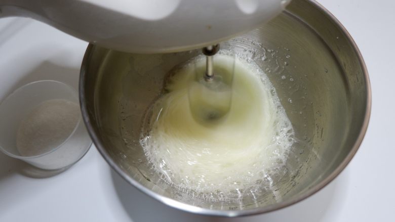 轻芝士蛋糕（6寸）,蛋白加入几滴柠檬汁，分三次加入细砂糖用电动打蛋器打发。第一次在出现粗泡的时候加入1/3