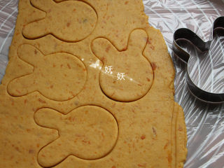 红薯饼干,台面上铺保鲜膜，将面团擀成大约3,4毫米的厚度，用模具压出形状。