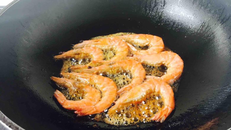 油焖糖醋大虾,当油温六成热时放入鲜虾，把两面炸成金黄色。