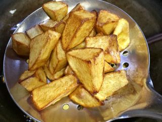 馋嘴孜然麻辣焦香土豆,大约五分钟后土豆收缩，表皮金黄，焦脆，可以关火，捞起土豆丁