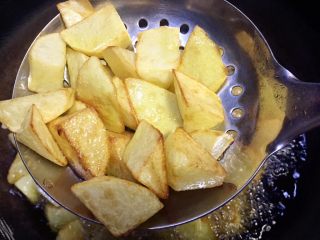 馋嘴孜然麻辣焦香土豆,搅动土豆使其油炸均匀，两分钟后表皮已经有焦黄色了，继续油炸