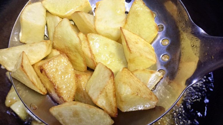 馋嘴孜然麻辣焦香土豆,搅动土豆使其油炸均匀，两分钟后表皮已经有焦黄色了，继续油炸