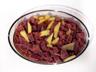 黑椒牛肉松,浸泡好的牛肉用水冲洗净放入盆中，加入50毫升料酒和少许姜片腌制30分钟。