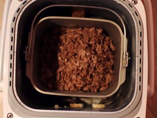 黑椒牛肉松,放入面包机中按果酱程序炒制，中途用锅铲翻匀牛肉松三次。