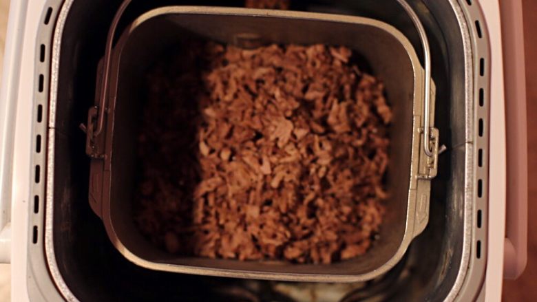 黑椒牛肉松,放入面包机中按果酱程序炒制，中途用锅铲翻匀牛肉松三次。