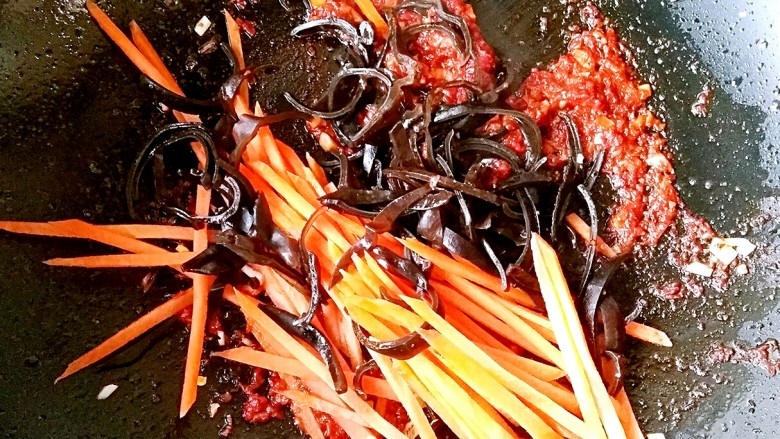 鱼香白菜帮,下入胡萝卜丝和木耳丝，翻炒至胡萝卜丝变软。
