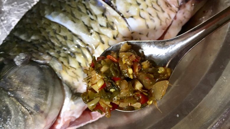 清蒸剁椒过江鱼,往鱼肚子里和鱼鳃位置塞入泡椒末，大葱细节，大蒜末老姜末（留一点放在鱼的表面用），