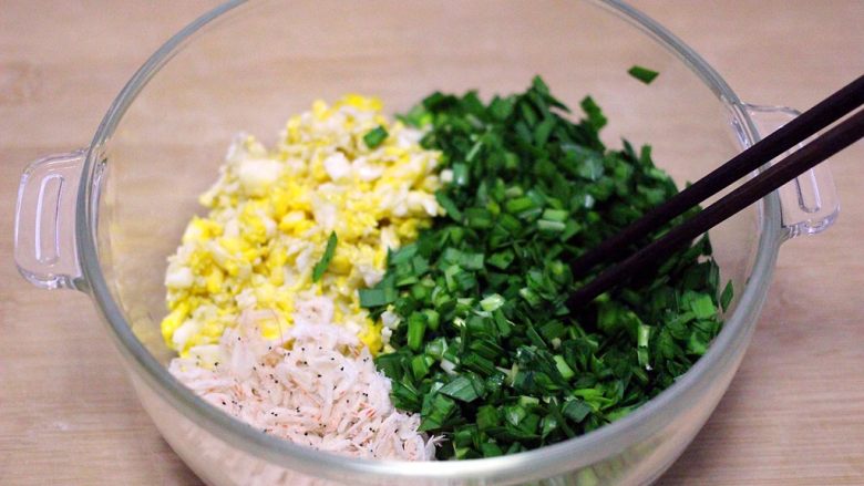韭菜鸡蛋花样包子,把韭菜用刀切成碎末、加入炒好的鸡蛋和虾皮