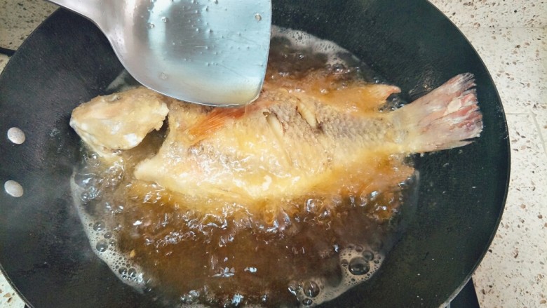 家常糖醋鱼,一面炸定型翻面，一边炸一边往鱼身上浇油