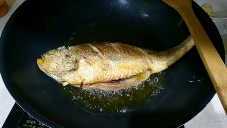 香辣黄花鱼,双面炸至微黄。鱼捞起，倒出多余的油，留一小部分后面用。