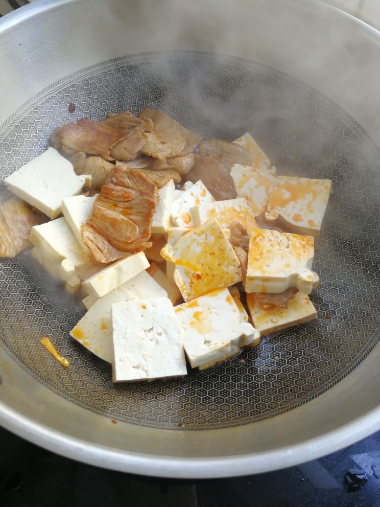 零基础家常炖菜之白菜粉条炖豆腐,锅里放油，少许辣椒油，先放肉炒下，再放入豆腐。