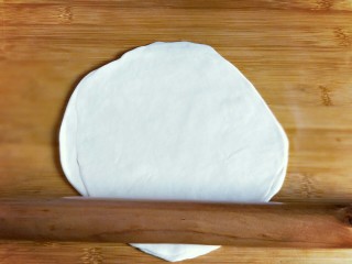 做饼＋嫩牛柳卷饼,再旁边将另一个年面团也擀开成同样大小，盖上抹了油的面片上，叠加起来，再将叠加好的双层面片擀开，擀得又大又圆。