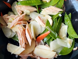 广东罗汉斋,加入笋，腐竹和荷兰豆，再加入适量盐和鸡精翻炒均匀。
