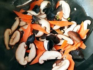 广东罗汉斋,放入木耳，胡萝卜和香菇翻炒至香菇，胡萝卜变软，木耳在锅中劈啪作响。