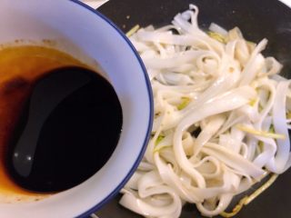 干炒牛河,加入适量酱汁，仍用筷子炒匀。