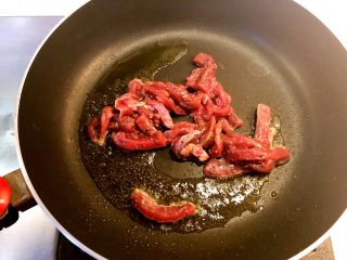 干炒牛河,热锅下油，下入腌制好的牛肉走油，一变色就捞起。