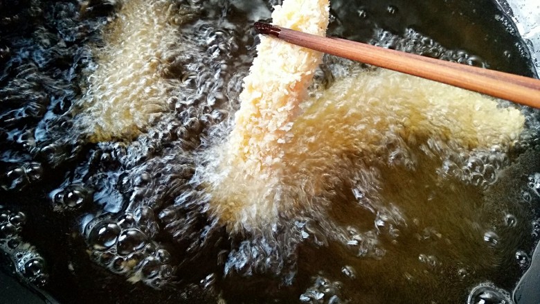 香酥龙利鱼柳,将裹好面包糠的鱼柳挨个儿的下油锅。