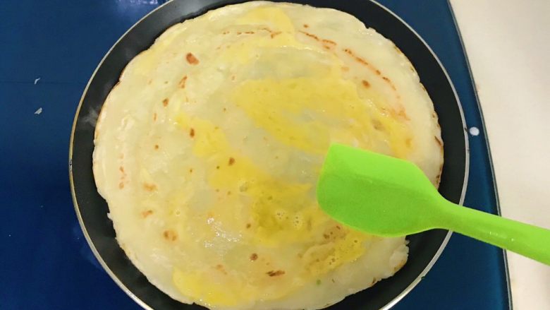 油条玉米面杂粮煎饼,用硅胶刮刀把蛋液涂抹均匀