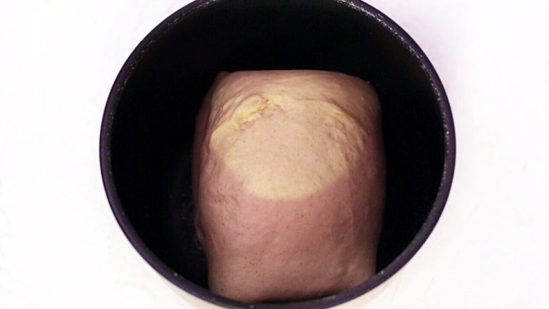 蜜豆爱心吐司,经过俩次对折的面团放入盆中，盖保鲜膜，冰箱冷藏松弛20分钟。