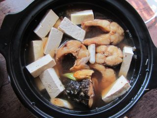 砂锅鱼炖豆腐,加入鱼块、豆腐、炒好的酱汁（不要多，和鱼块持平即可）、料酒、白糖加盖炖煮