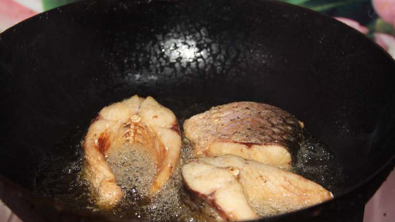 砂锅鱼炖豆腐,腌好的鱼放入热油中炸至表面金黄备用（鱼炸以前要用厨房纸喜欢干表面水分）