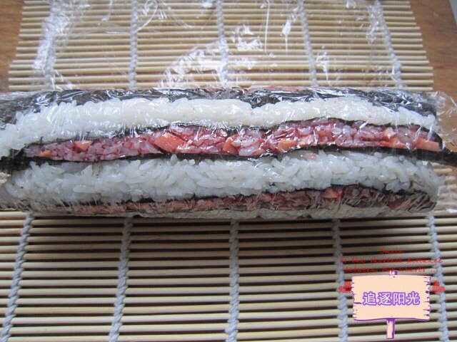 花朵🌺寿司🍣,取开竹帘和保鲜膜，将卷好的寿司卷切成段摆盘开吃。