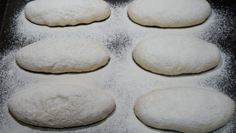 全麦椰片麻薯软欧面包,发酵好的面包取出筛上面粉。