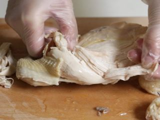 红油手撕鸡,将鸡肉撕成合适食用的条状，放入盘中。