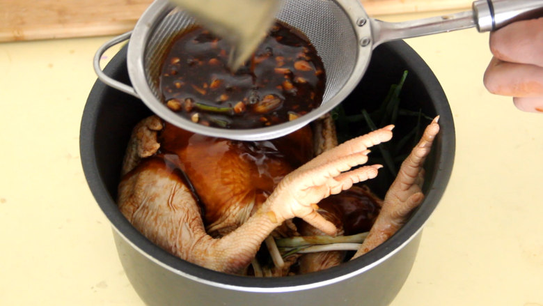 电饭煲焖鸡,把鸡放在上面，然后用滤网滤掉料汁里面的姜蒜末。