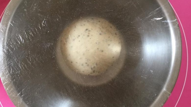 黑芝麻吐司,揉好的面团滚圆，放入容器盖上保鲜膜。25-28温度下发酵至2-2.5倍大
