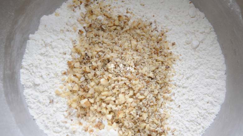 看得到核桃仁的核桃酥 香酥可口真材实料超满足,过筛后的粉类加入切碎后的核桃仁，拌匀。