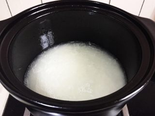 腊肠煲仔饭,淘洗净的大米里倒点油入锅加水开大火煮。