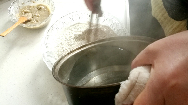 做饼+千层葱油饼,随后将开水慢慢倒入大盘面粉里。