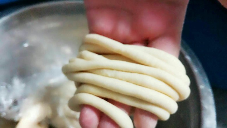 馓子,把醒好的面团搓成筷子粗的长条状。尽可能的搓细一点，如果不好搓手上就弄一点点温水，有助于搓成长条。