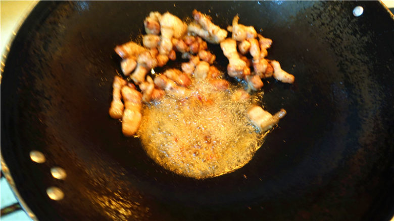 茄子甜椒烧五花肉,将五花肉推到锅边，放一大勺豆瓣酱在底油里炒香。