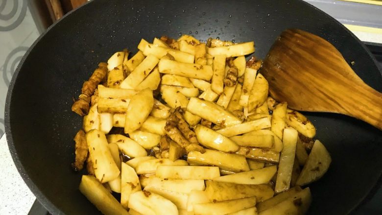 家常爆炒土豆条,下入土豆条翻炒均匀，加入半小匙盐，翻炒。