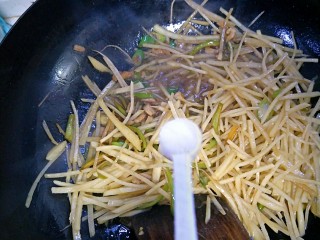 家常土豆丝,翻炒均匀后，倒入一勺盐。