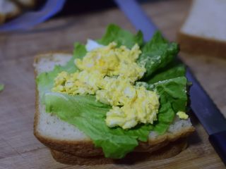 鸡蛋三明治,铺上生菜叶子。叶子上加一勺鸡蛋酱料。