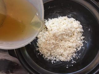腊肠砂锅煲仔饭,放入泡好的米，倒入泡发干香菇的水