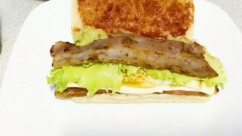 双层培根三明治,再铺一层培根，上层面包片上涂上辣椒酱。